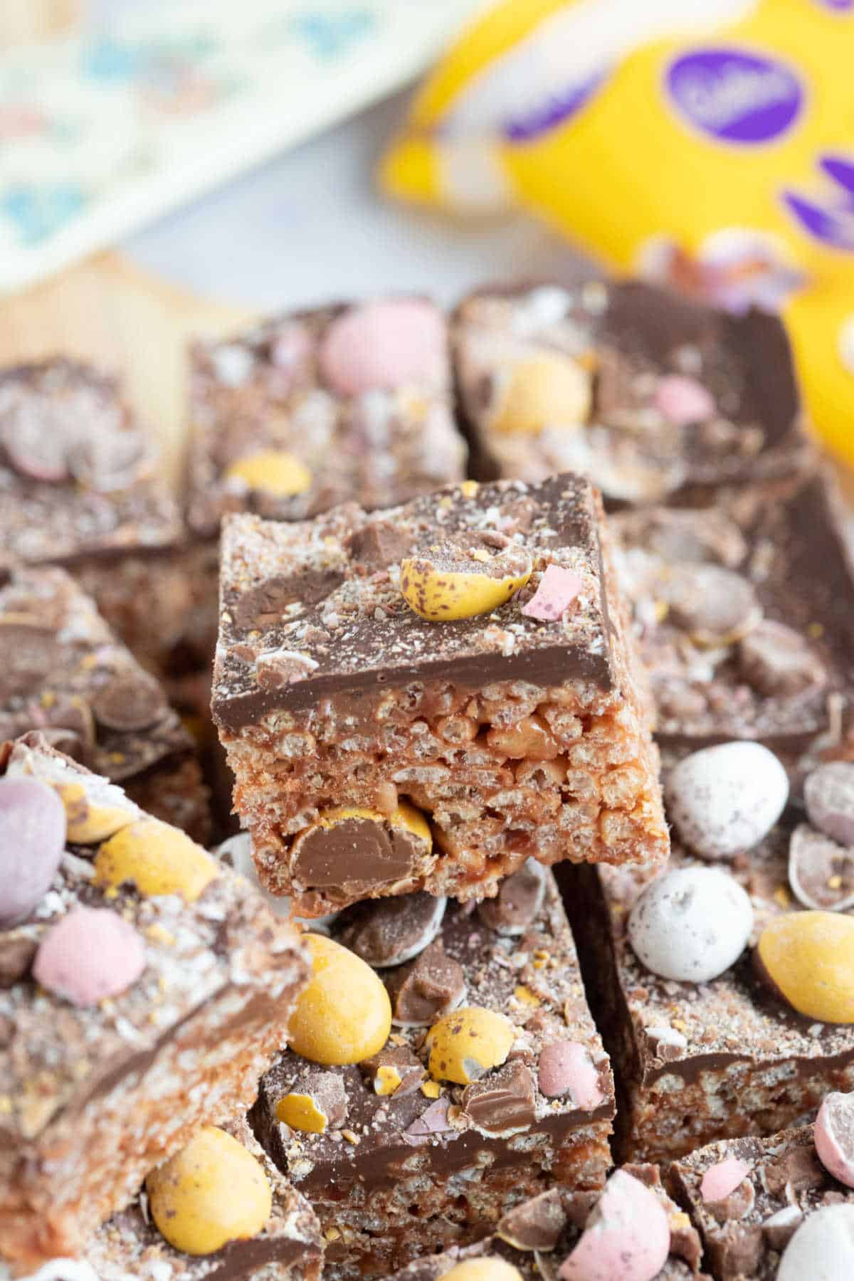 Rice krispie square topped with chocolate and mini eggs.
