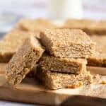 A stack of no bake peanut butter flapjacks on a wooden board.