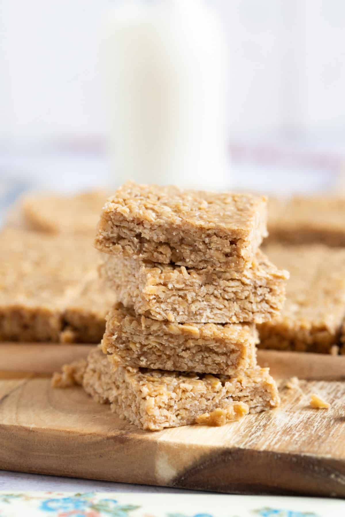 A stack of no bake flapjacks with a glass of milk.