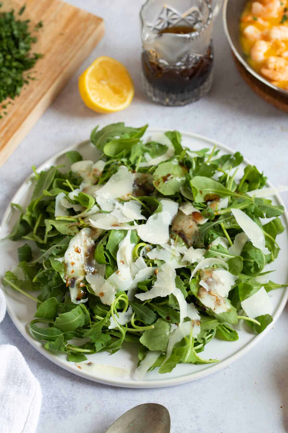 Rocket and Parmesan salad with a jug of balsamic dressing on the side.