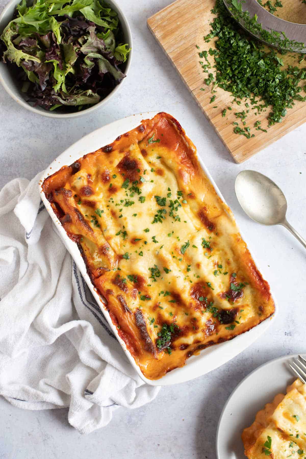 Spinach and ricotta cannelloni in a white baking dish,