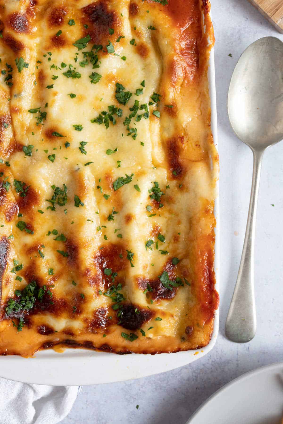 Spinach and ricotta cannelloni in a white baking dish.