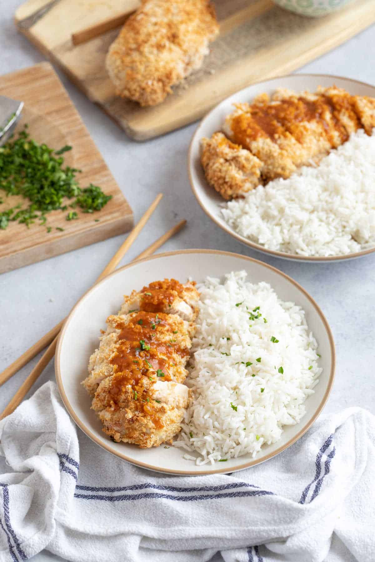 Air fryer chicken katsu with rice and a pair of chopsticks on the side.