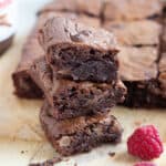 A stack of air fryer chocolate brownies with raspberries on the side.