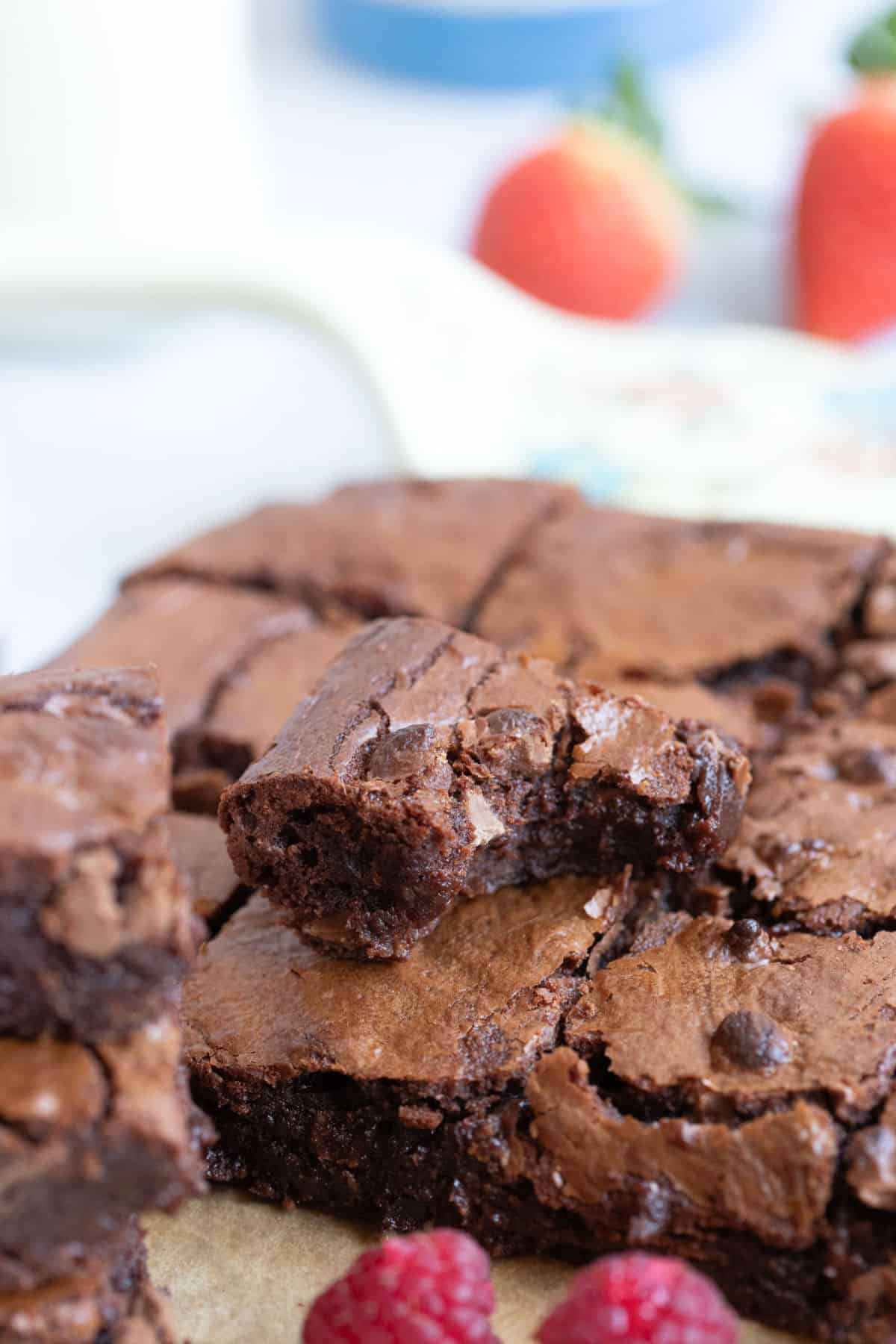 A half eaten brownie on top of more brownies.