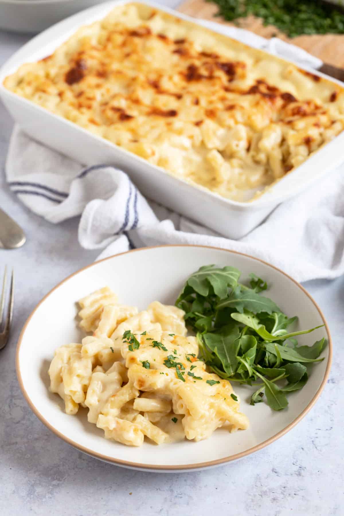 A plate of macaroni cheese with a green side salad.