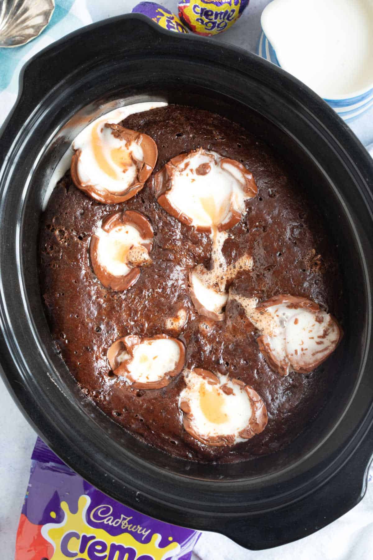 Slow cooker chocolate creme egg pudding in a black slow cooker basin.