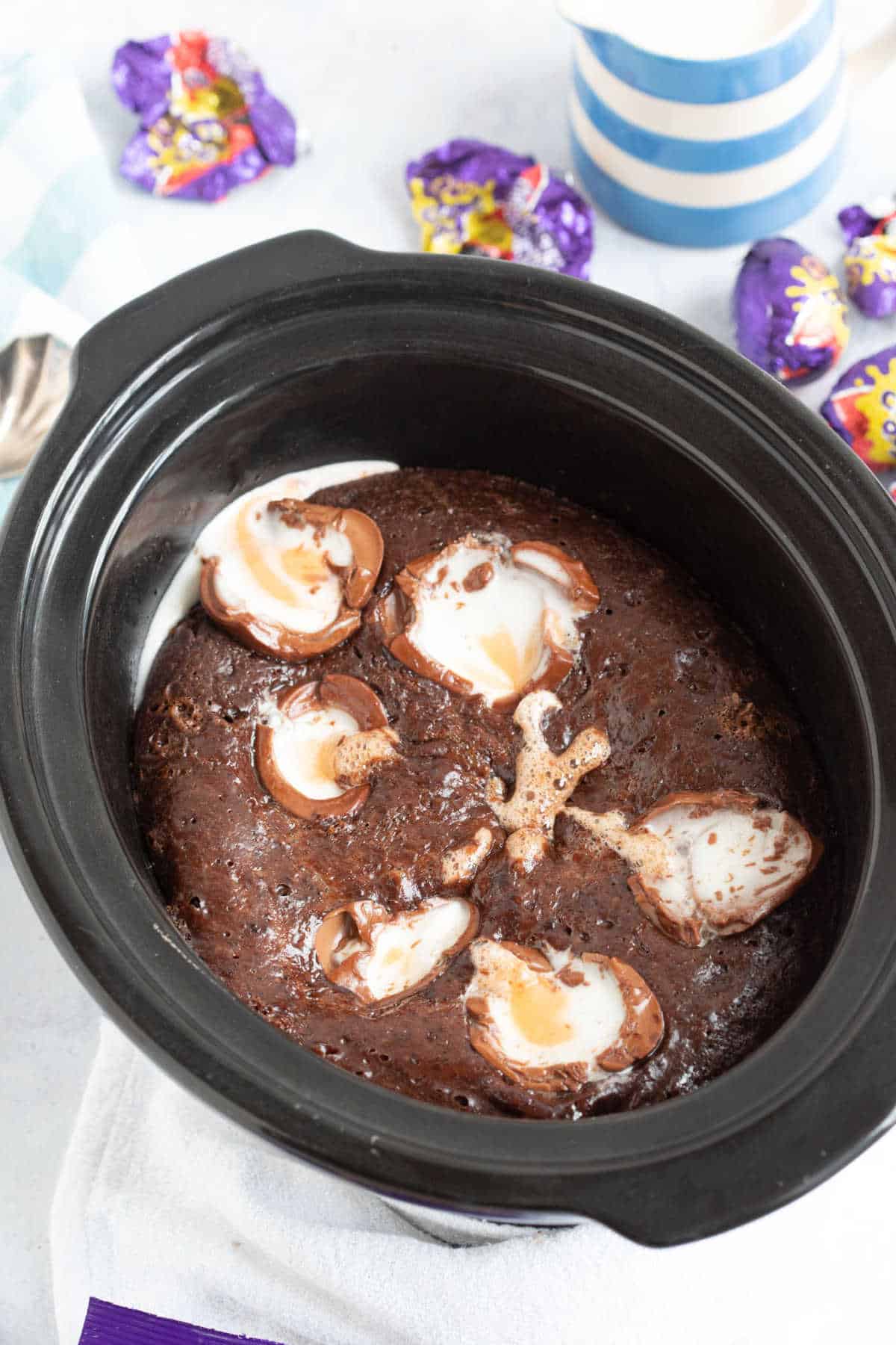 Slow cooker self-saucing chocolate pudding with halved Cadbury creme eggs on top.