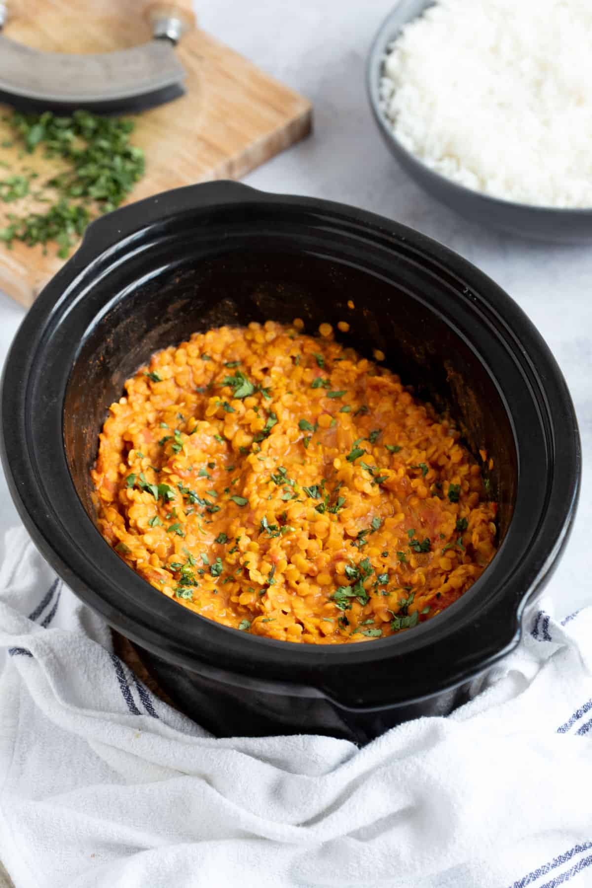 Red lentil dahl in a black crock pot.