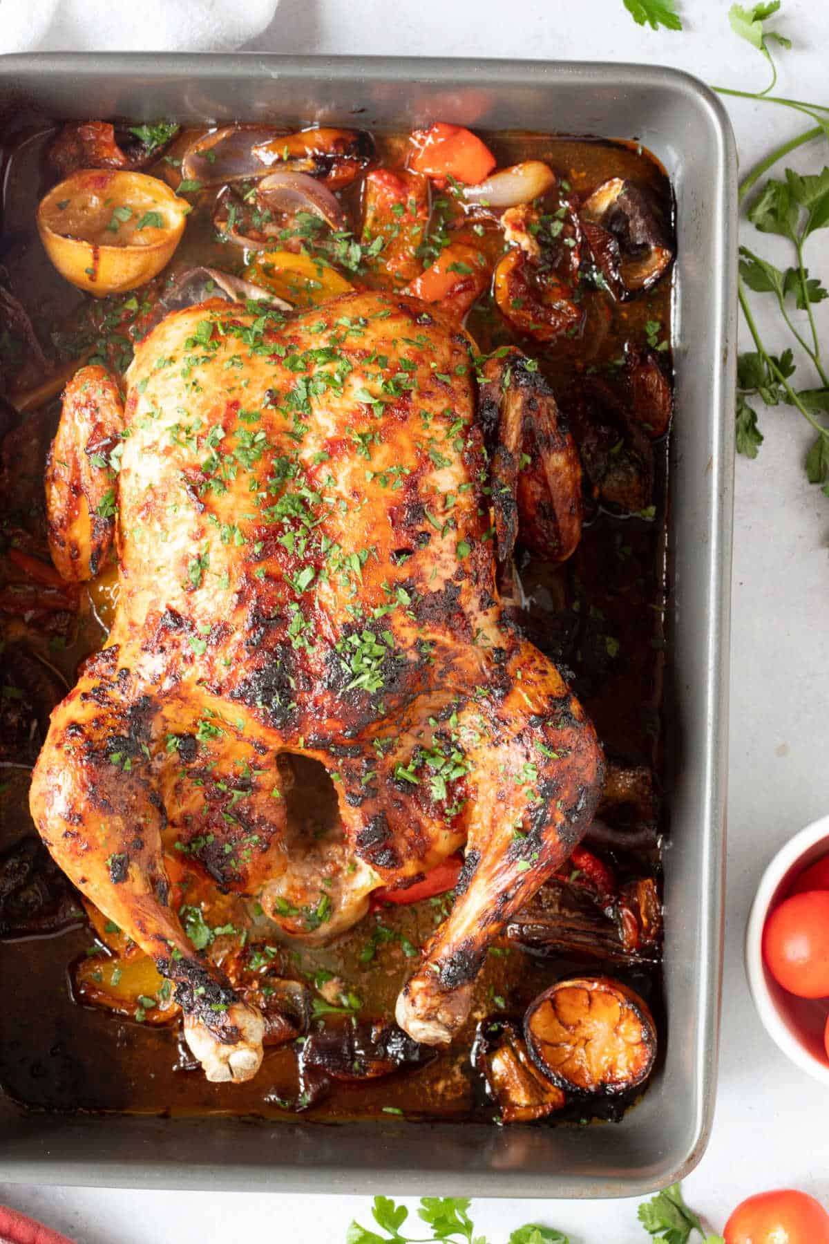 Whole chicken in roasting tin.