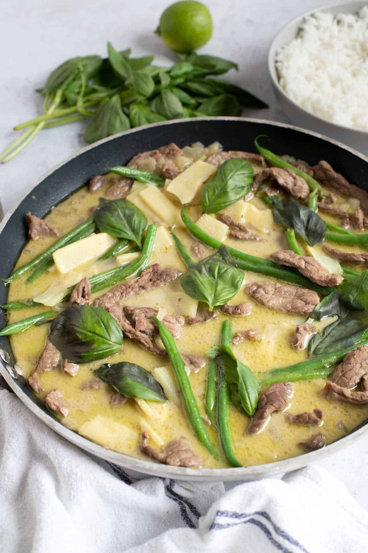 Thai green beef curry garnished with Thai basil.