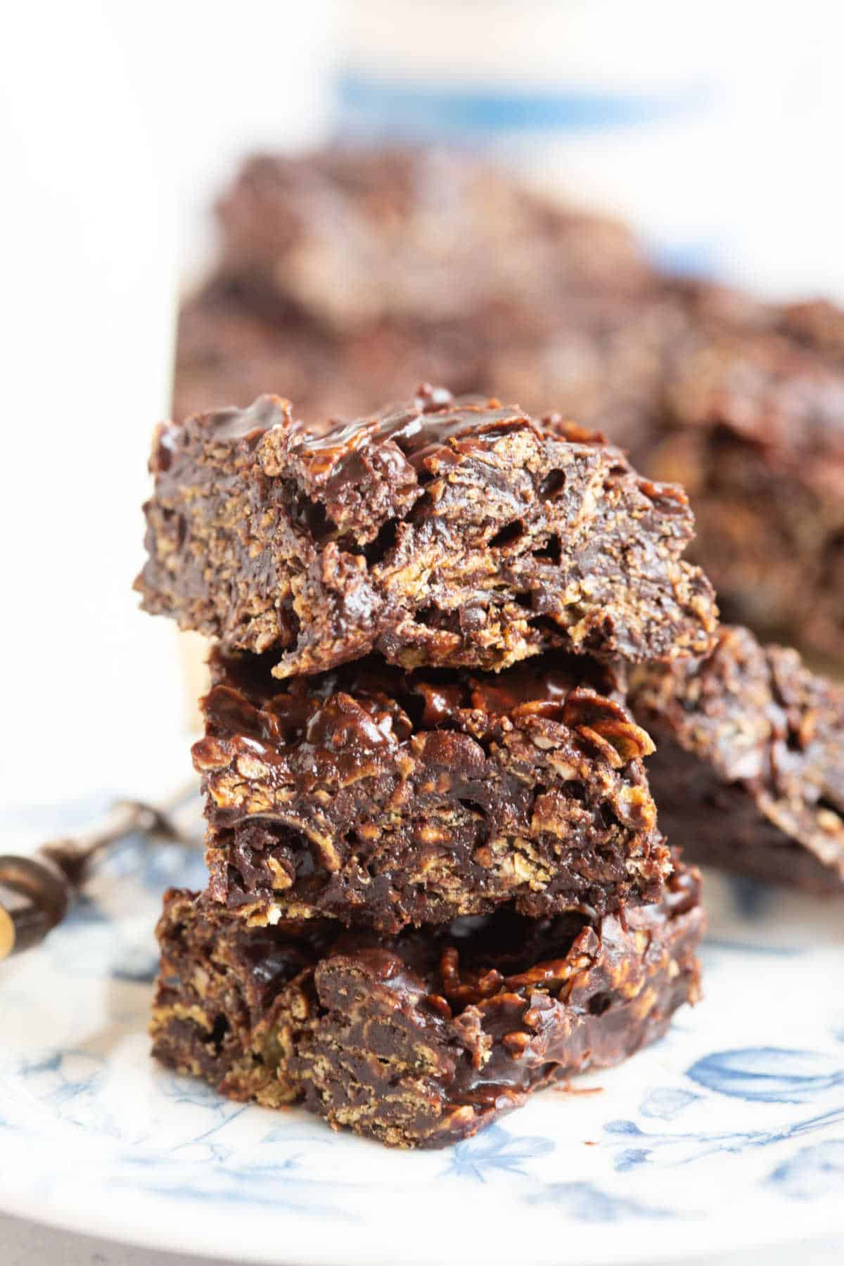 Chocolate cornflake cracknell bars on a blue and white plate.