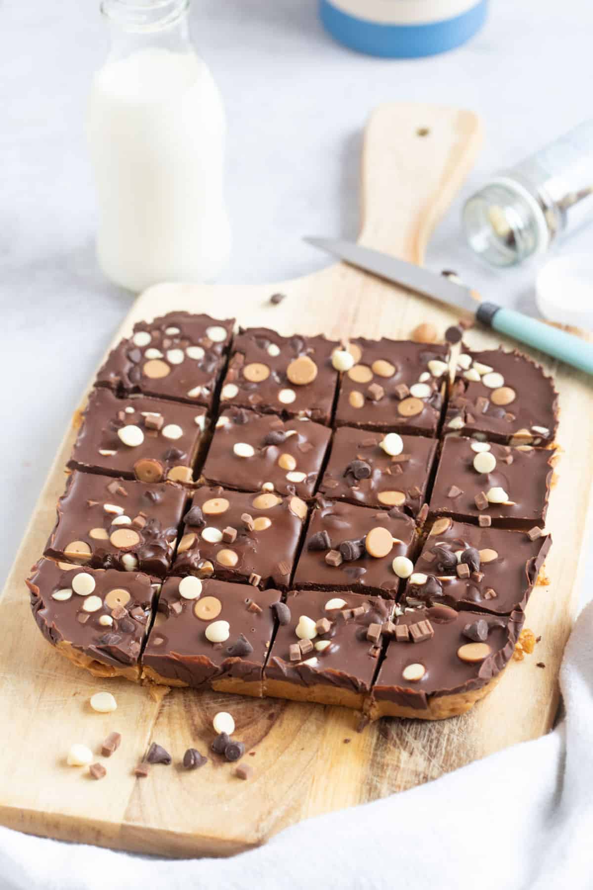 No bake chocolate peanut butter bars on a wooden board.
