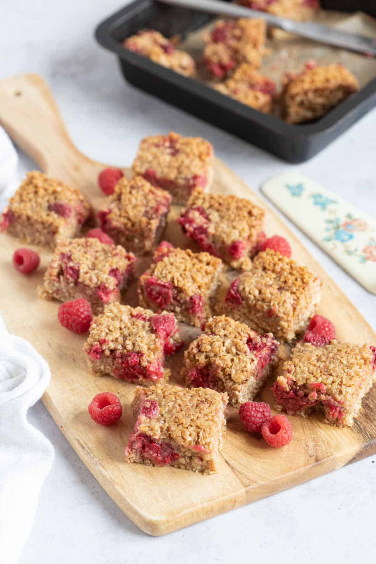 Raspberry flapjacks on a wooden board.