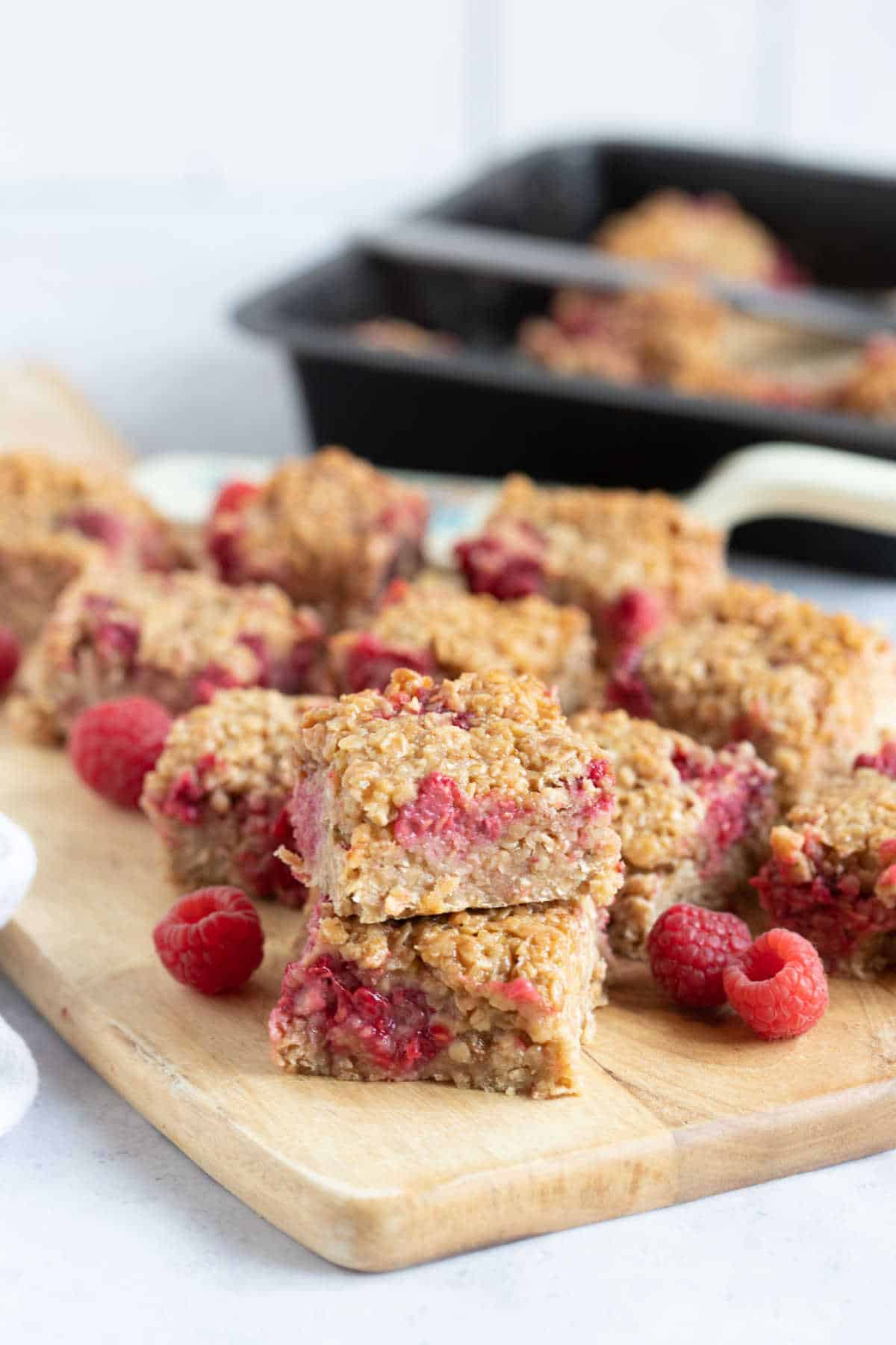 Raspberry flapjacks on a wooden board.