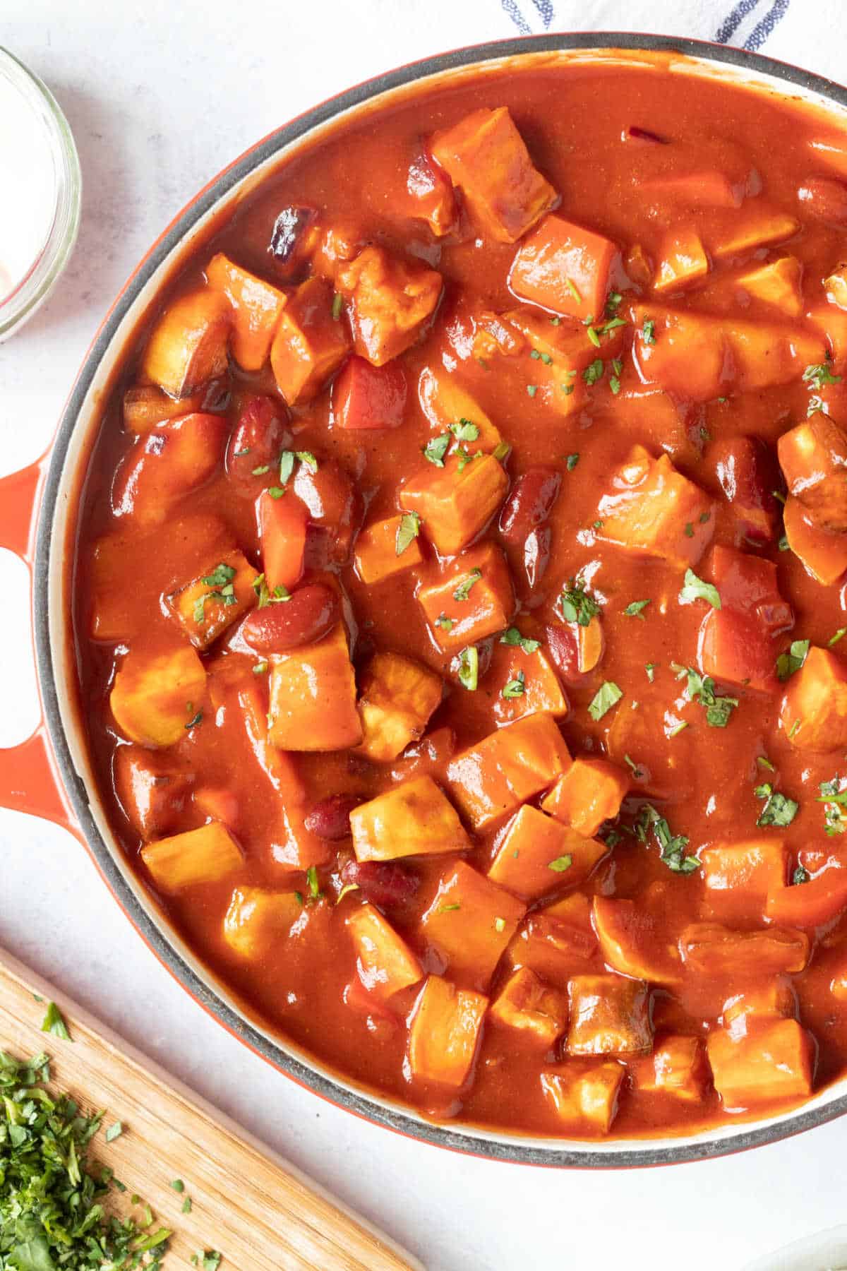 Bean and sweet potato chilli in a red pan.