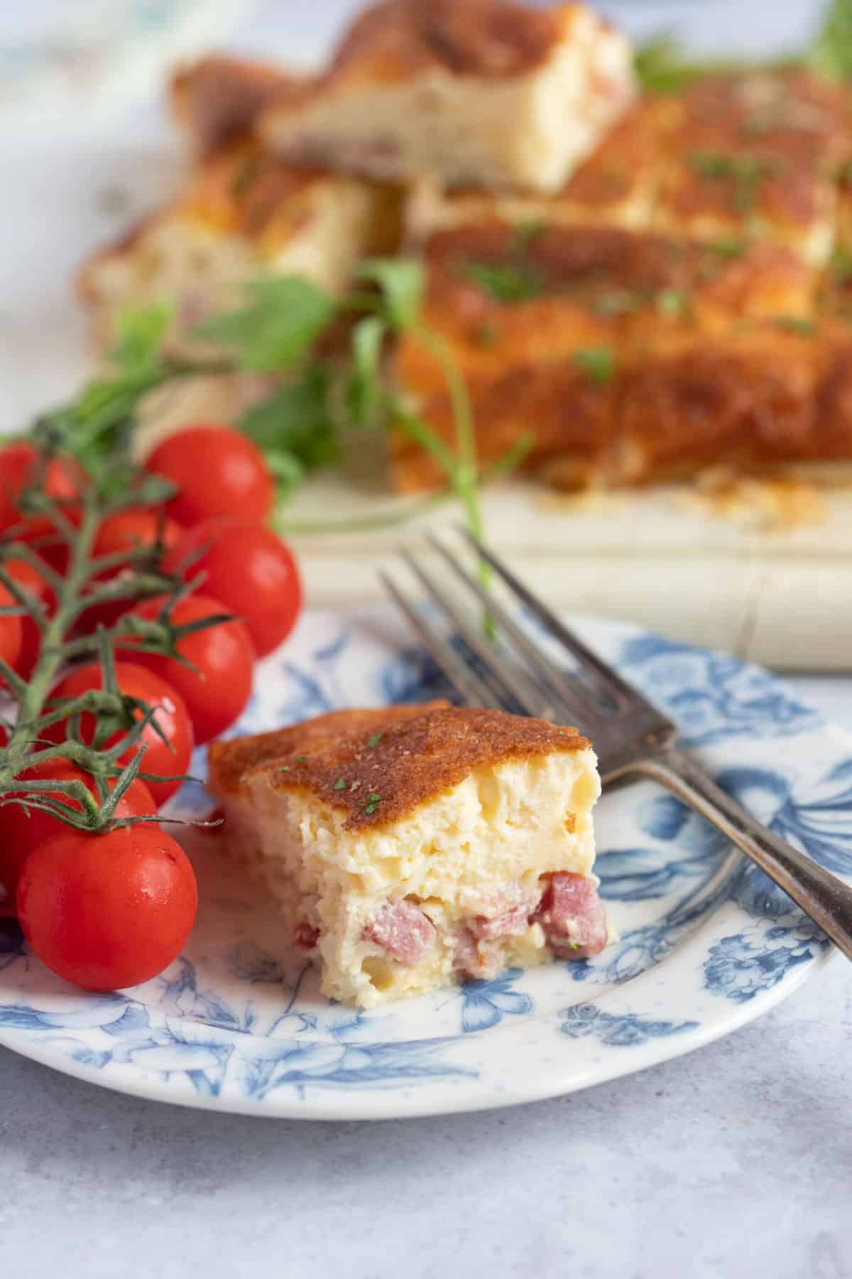 A slice of air fryer crustless quiche with tomatoes.