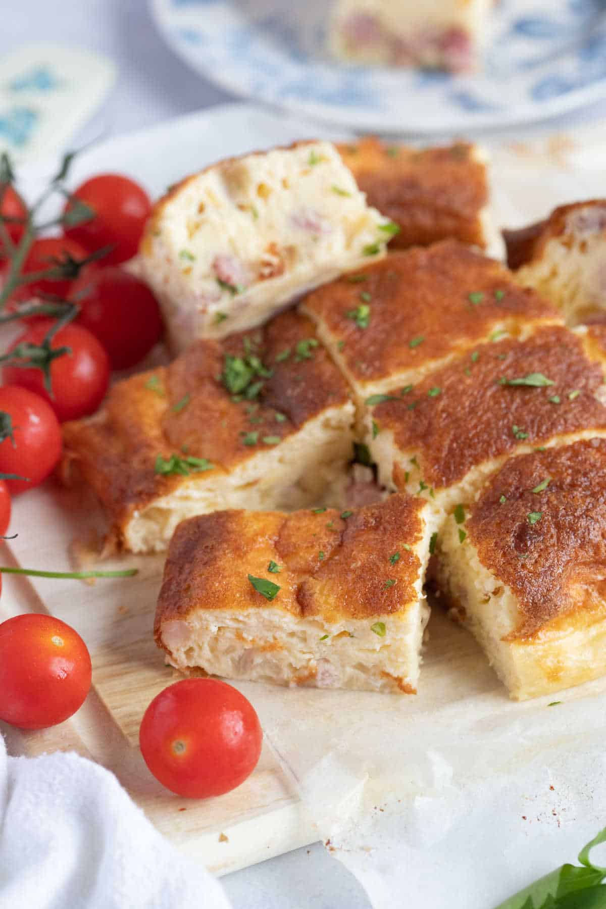 Slices of air fryer crustless quiche on a wooden board.