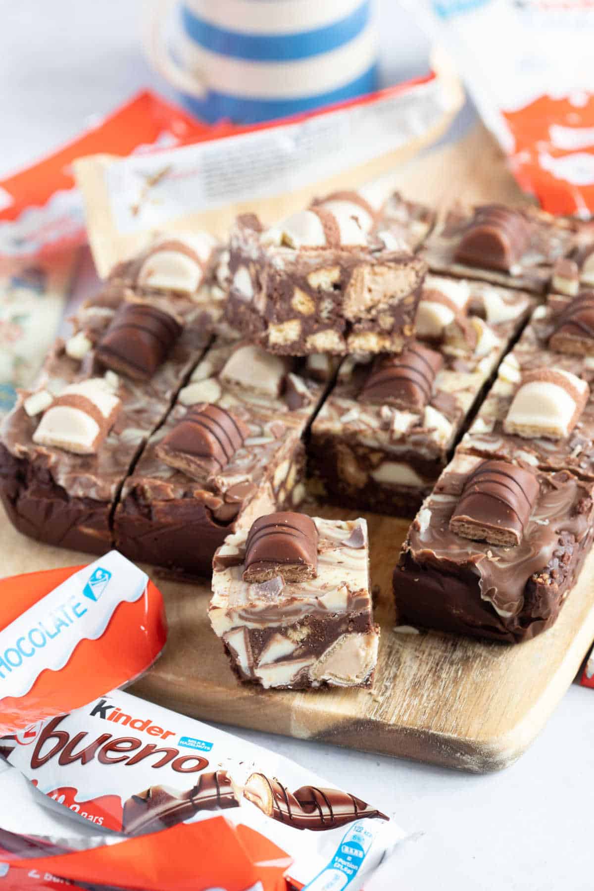 Kinder Bueno tiffin cut into bars on a wooden board.