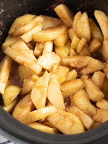 Slow cooker stewed apples in a black slow cooker basin.