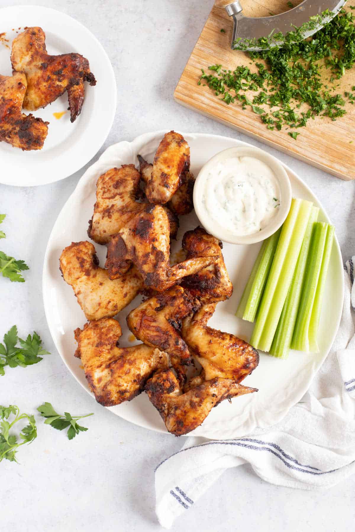 Chicken wings on a white serving plate.