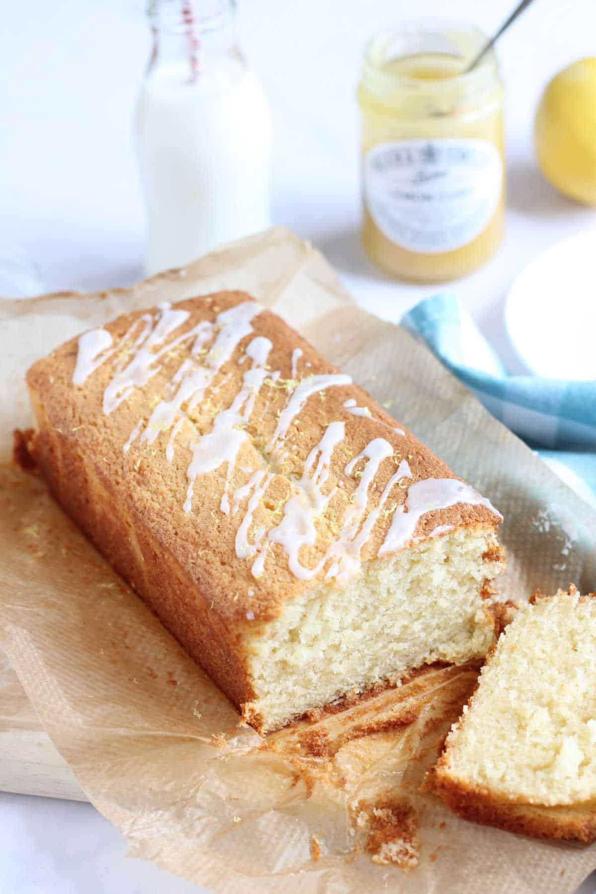 Fluffy and moist lemon curd loaf cake with a slice cut  off the end.