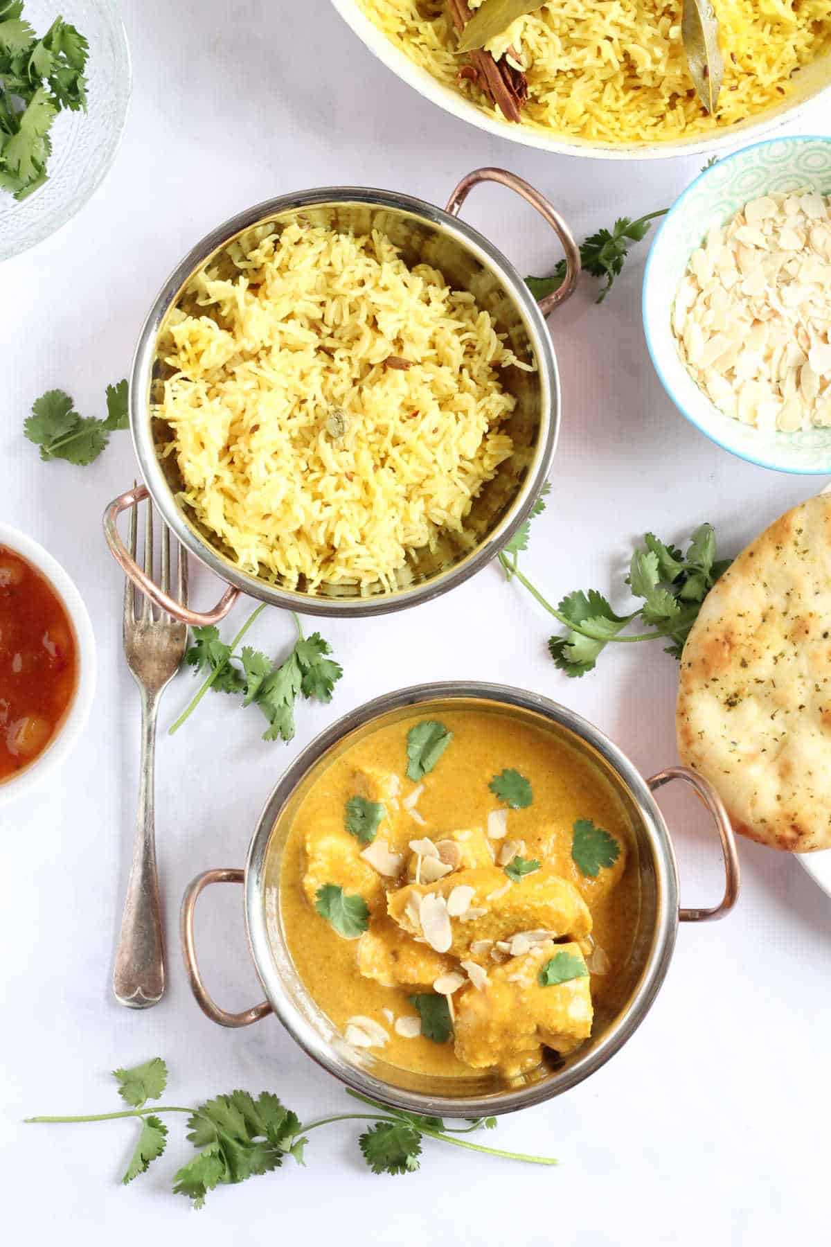 A bowl of creamy and mild chicken curry with pilau rice.