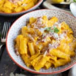 A bowl of creamy pumpkin and bacon pasta.