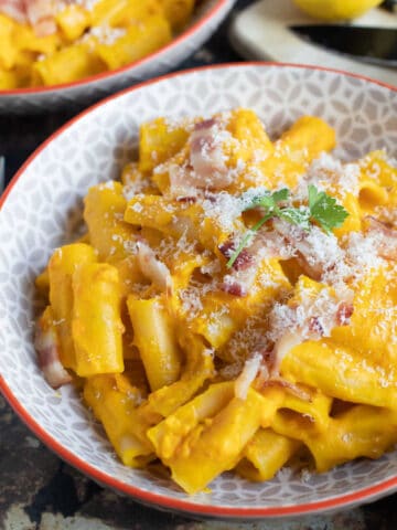 A bowl of creamy pumpkin and bacon pasta.