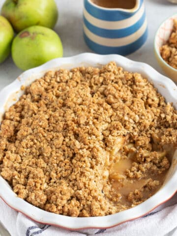 Sticky toffee apple crumble in a red pie dish.