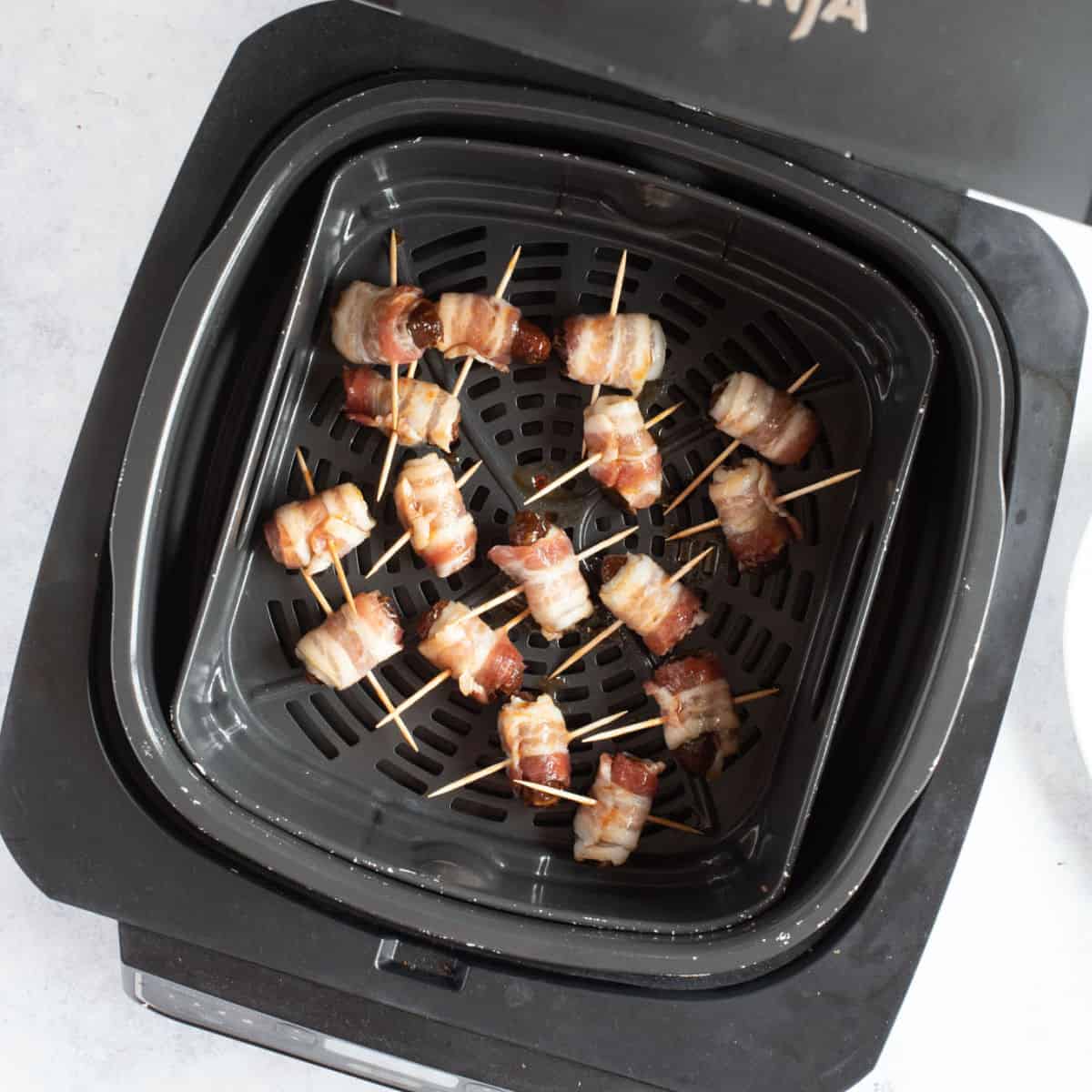 Devils on horseback in air fryer basket.