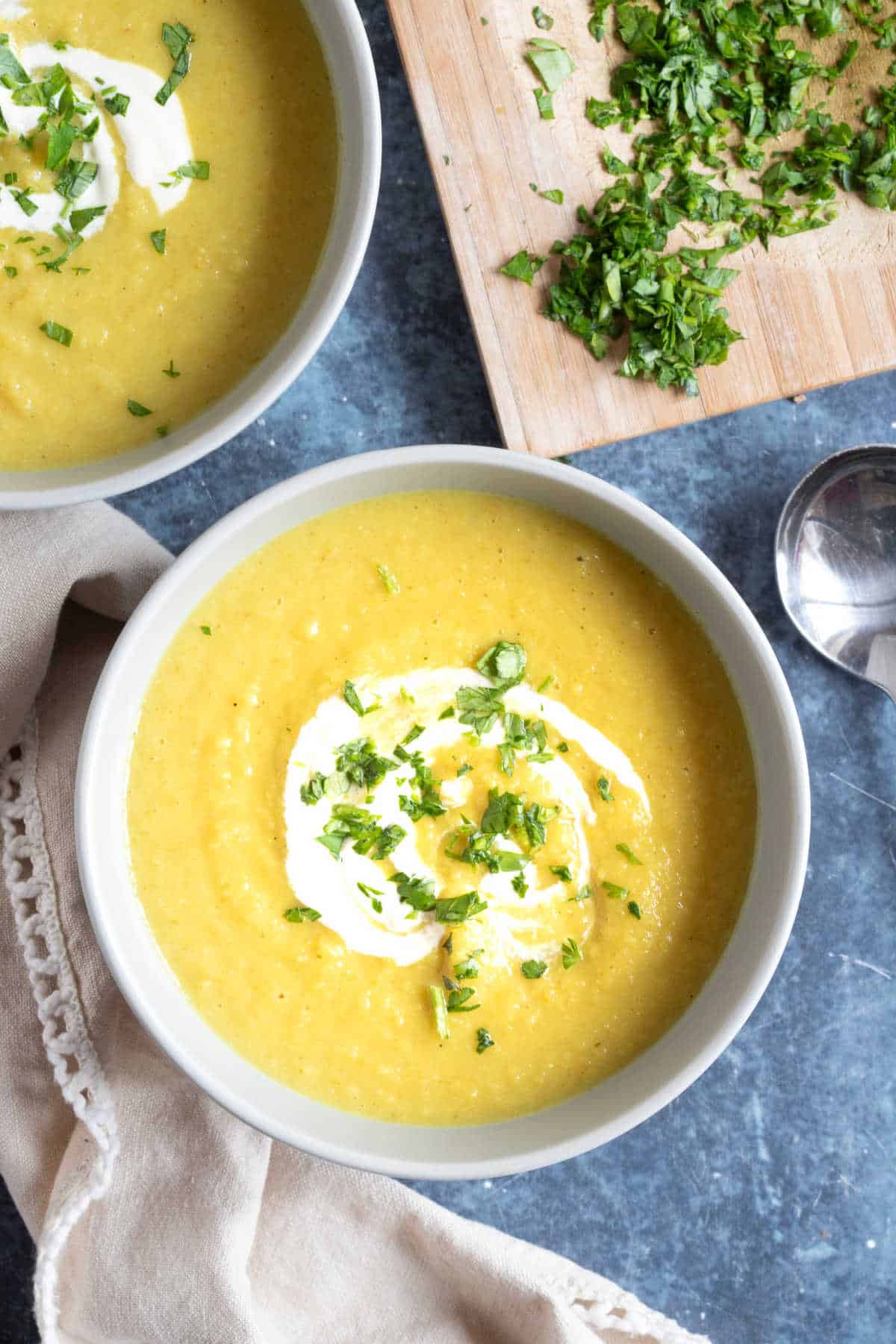 Spiced parsnip and apple soup in bowls with a creme fraiche drizzle.