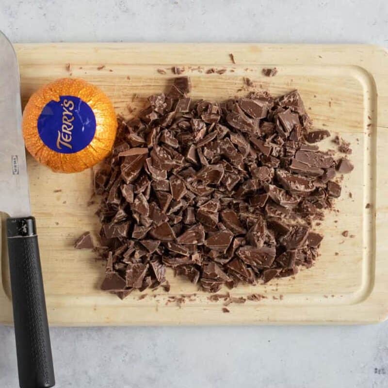 Chopped Terry's chocolate orange segments on a chopping board.