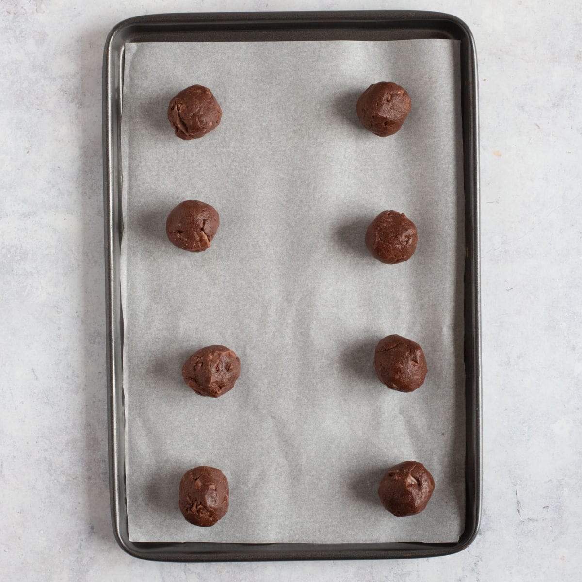 Unbaked chocolate orange cookies on a baking tray.