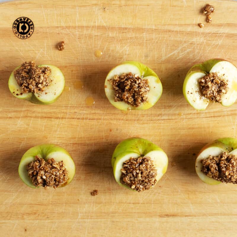 Apples with crumble topping on a wooden board.