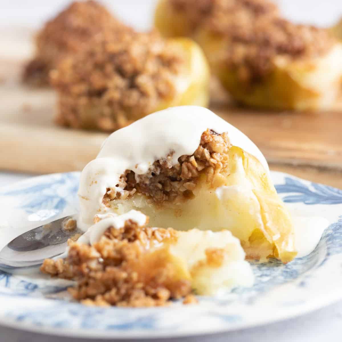 Air fryer baked apples on a plate with cream.