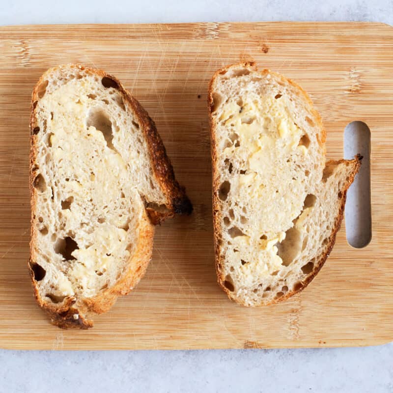 Two slices of bread spread with butter.