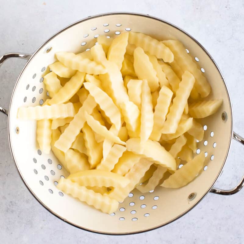 Homemade chips in a colander.