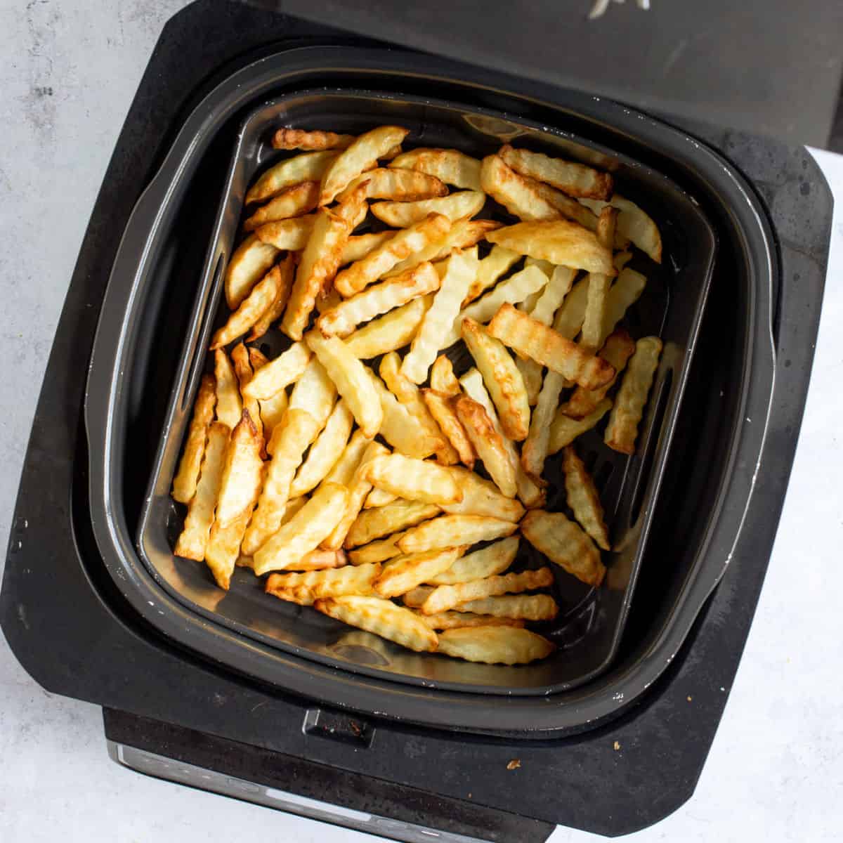 Air fried chips in air fryer basket.