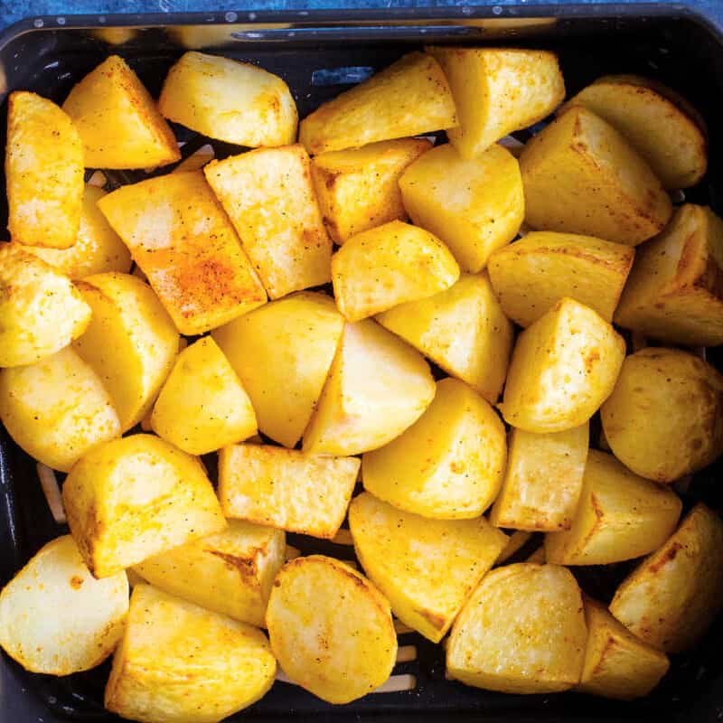 Potatoes in an air fryer basket.