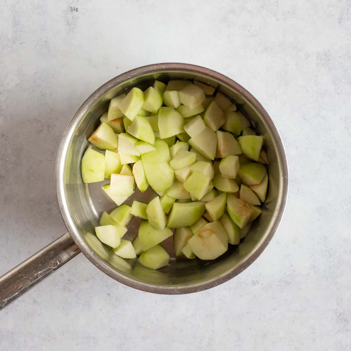 Chopped Bramley apples in a pan.