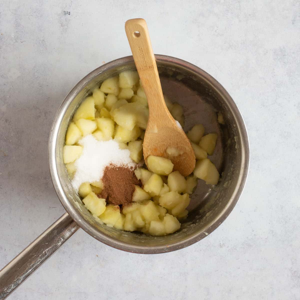 Stewed apples with cinnamon and sugar added to the pan.