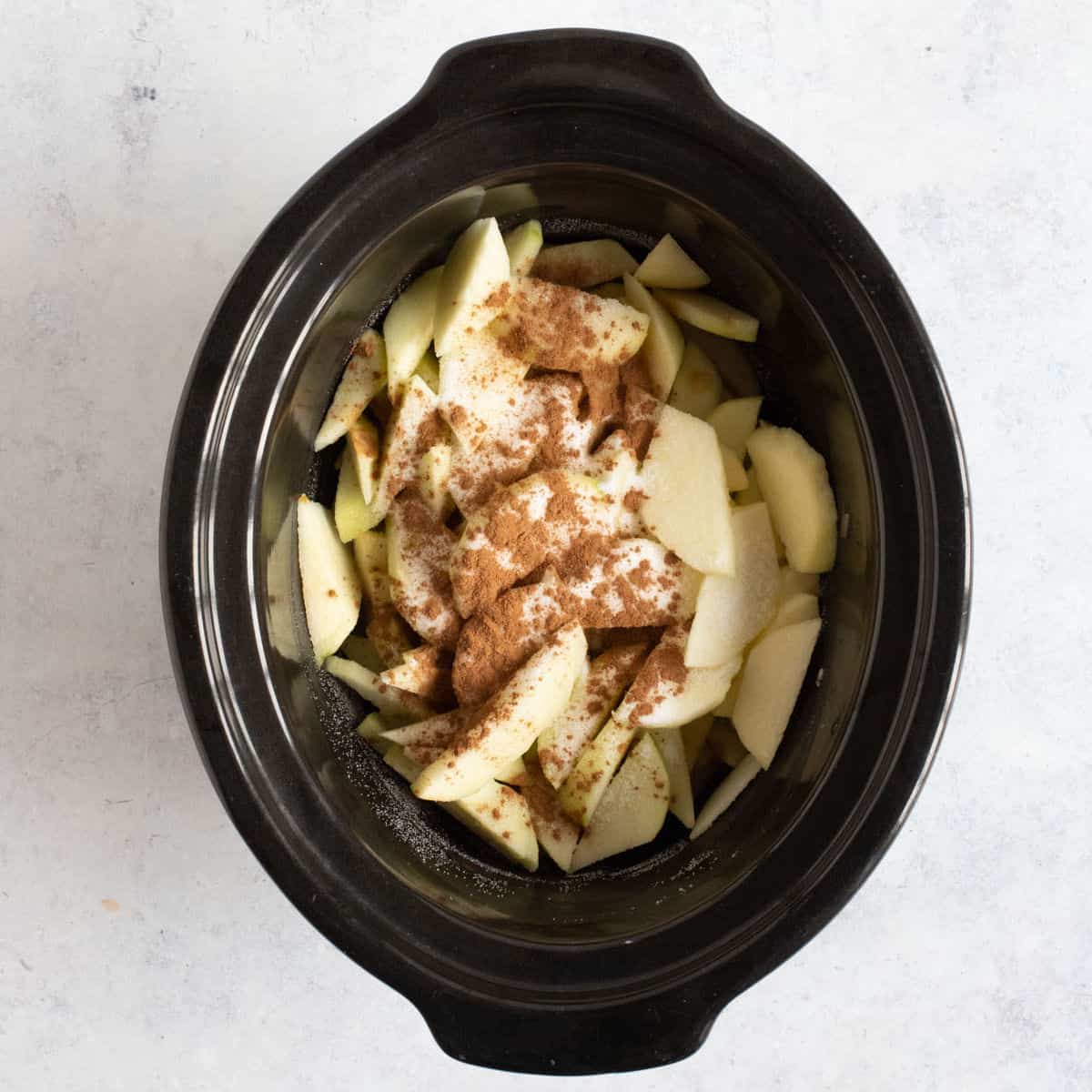 Sliced apples in a slow cooker.