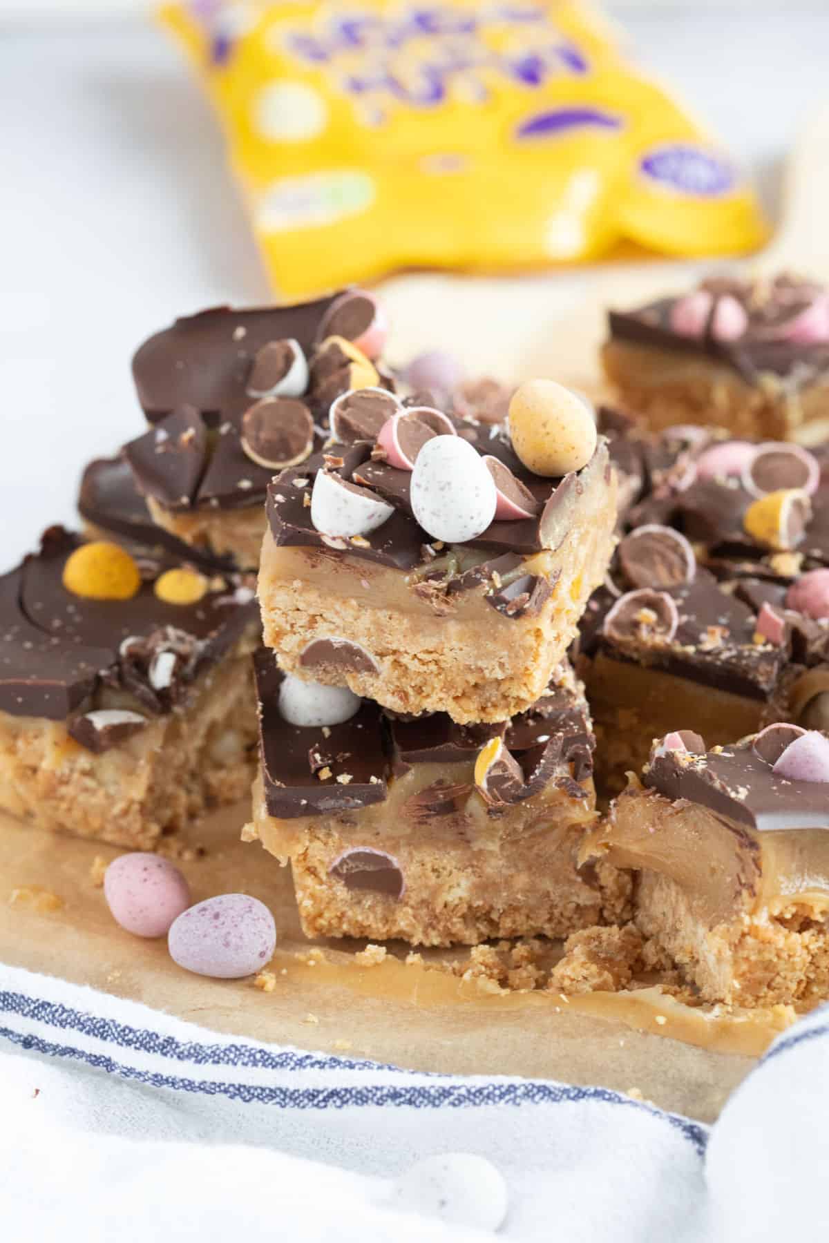 A stack of no bake mini egg millionaires bars.