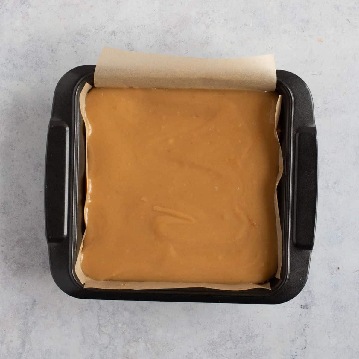 Caramel layer in a baking tin.