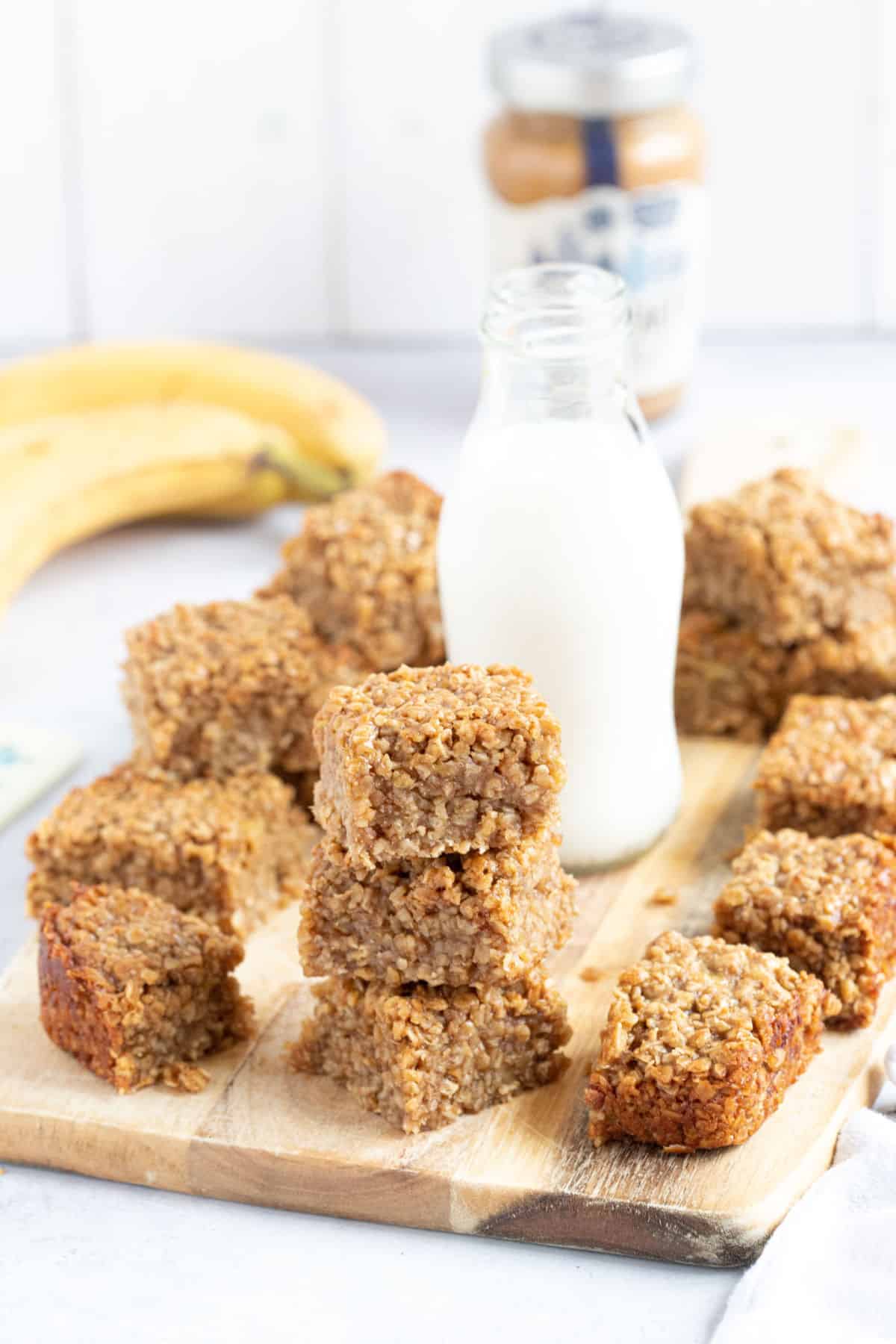 A stack of banana peanut butter and honey flapjacks on a wooden board.