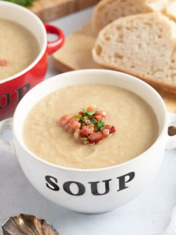 Celeriac and bacon soup in a white bowl.