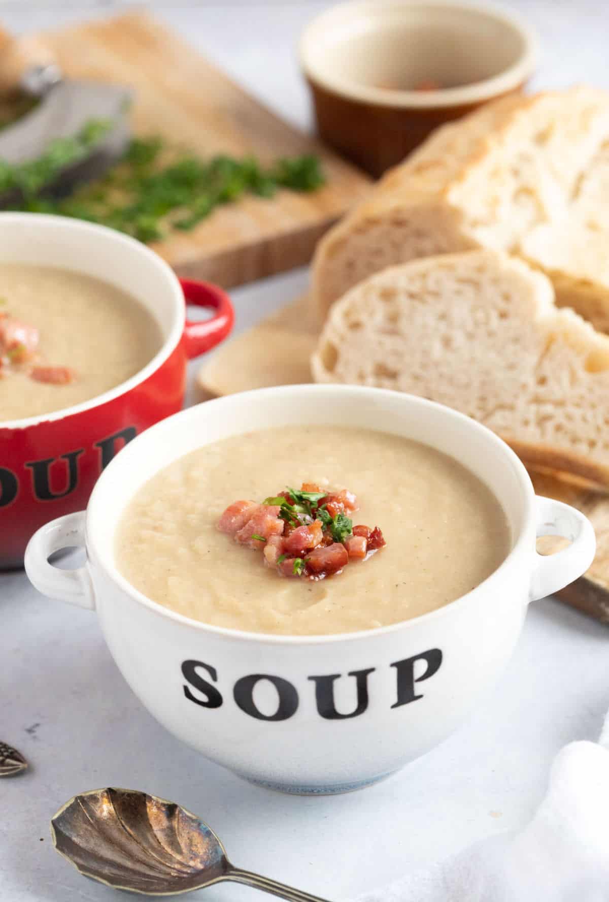 Celeriac and bacon soup in white bowl.