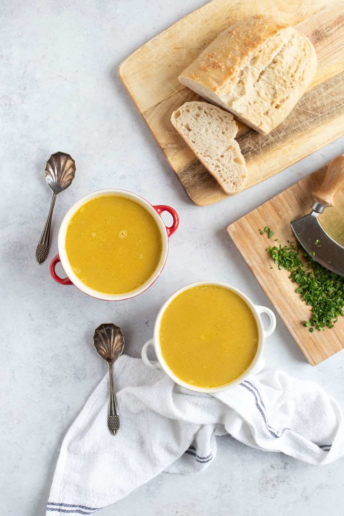 Two bowls of soup with crusty bread.
