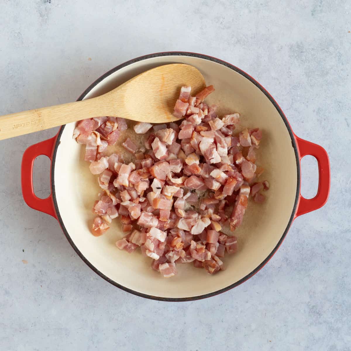 Bacon lardons frying in oil.